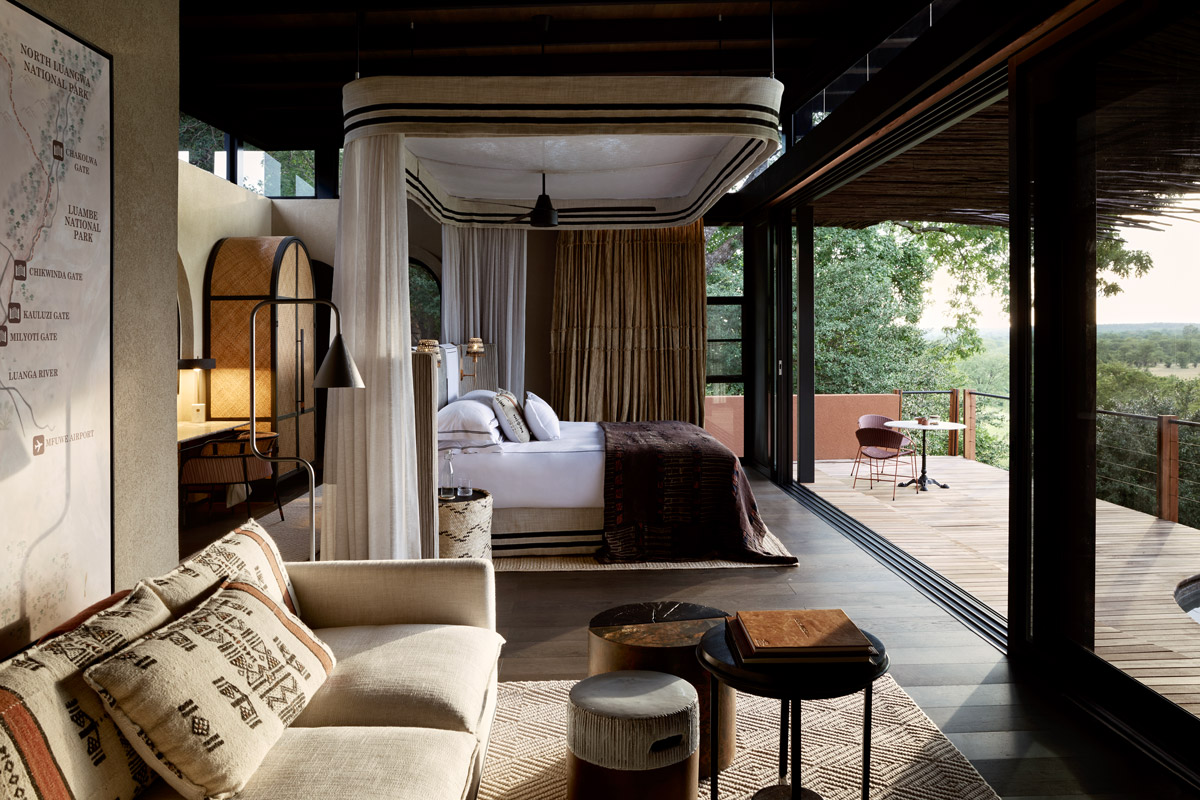 A Chichele Vista Suite with a four-poster bed, sitting area and open views onto the private veranda
