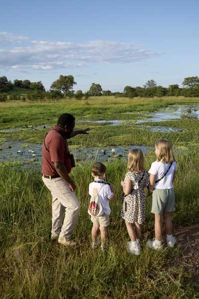 A guide showing children the wetlands at Chichele